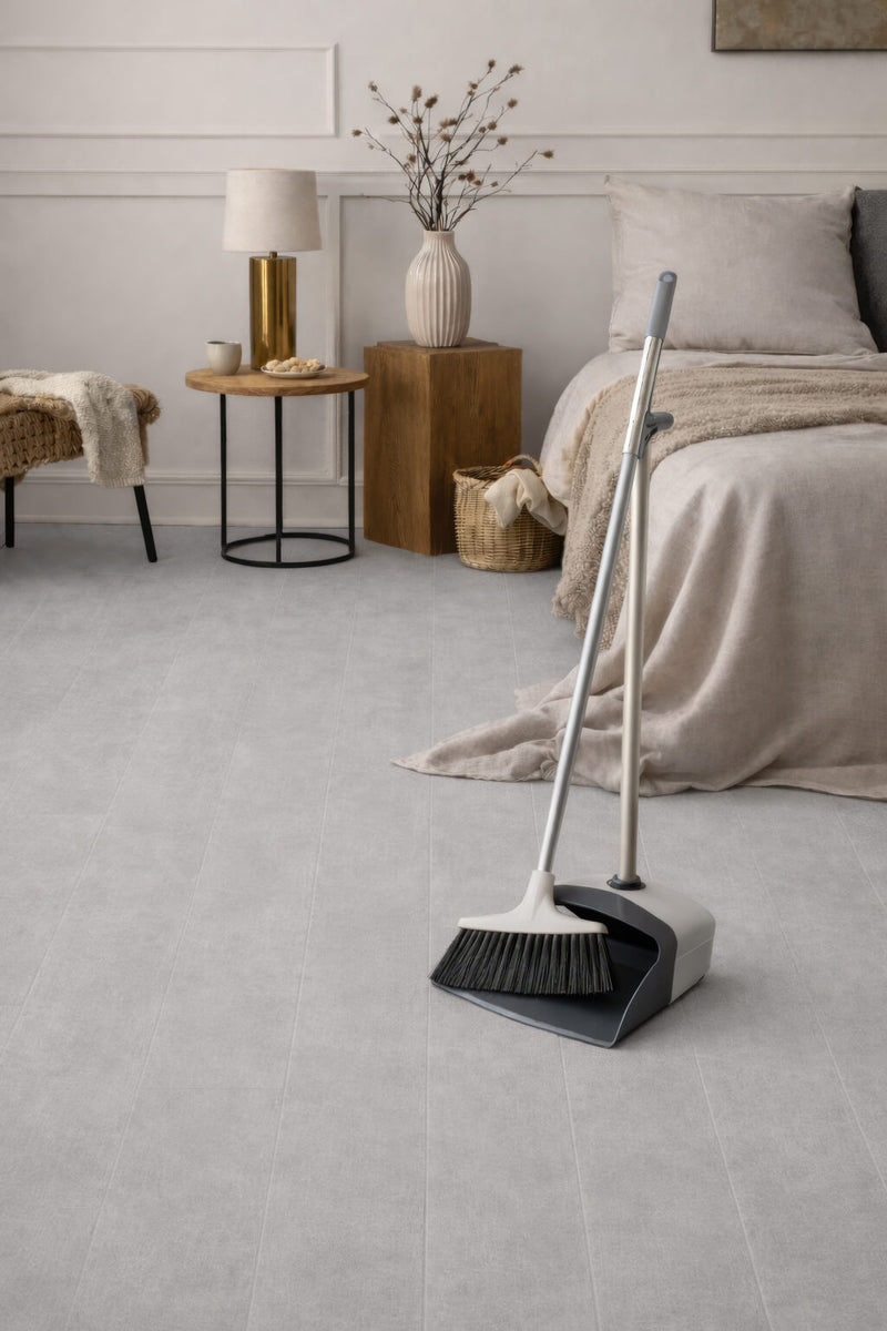 Broom and dustpan set on Waterblock X Kasu light grey stone-look floor in a bedroom