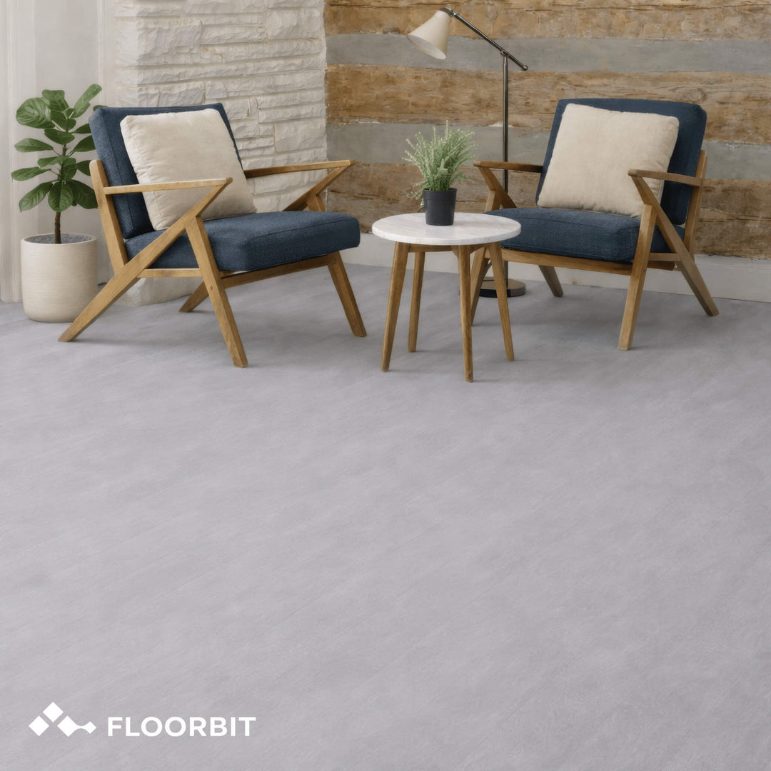 Waterblock X Kasu light grey stone-look floor with wooden chairs and a small table in a room setting, featuring the Floorbit brand.