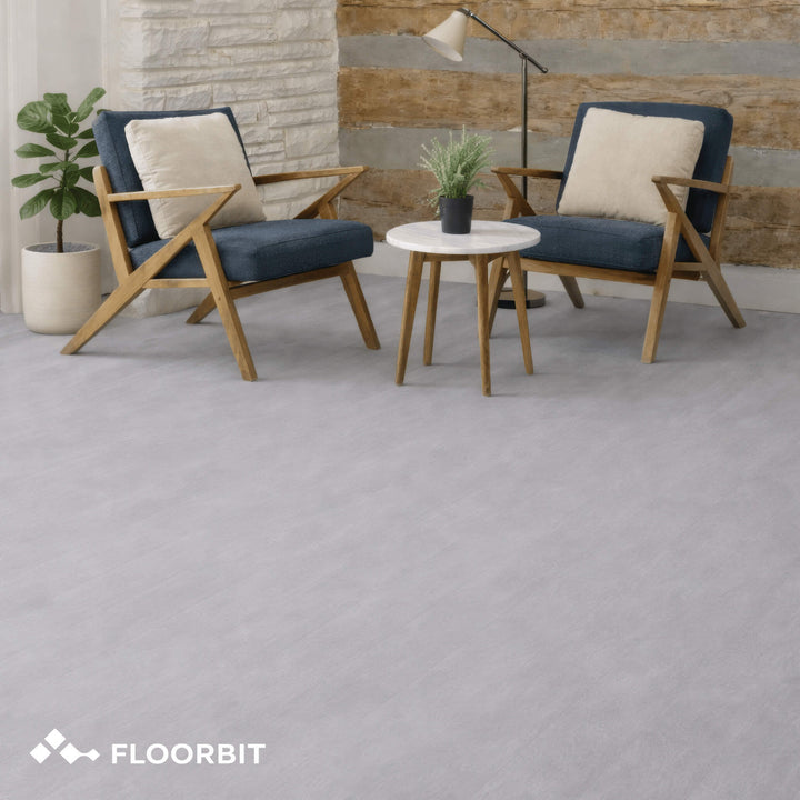Waterblock X Kasu light grey stone-look floor with wooden chairs and a small table in a room setting, featuring the Floorbit brand.