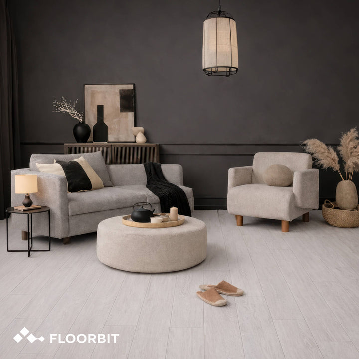 Modern living room with gray sofa, armchair, and round ottoman on a Waterblock X Mizu light brown floor.