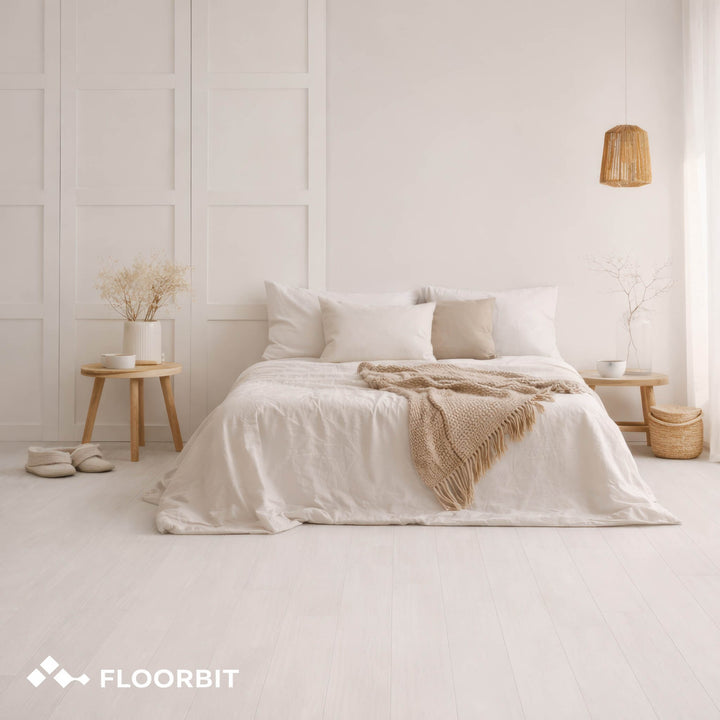 Neatly made bed with white bedding and beige blanket in a minimalistic bedroom with Waterblock X Mizu light brown floor.