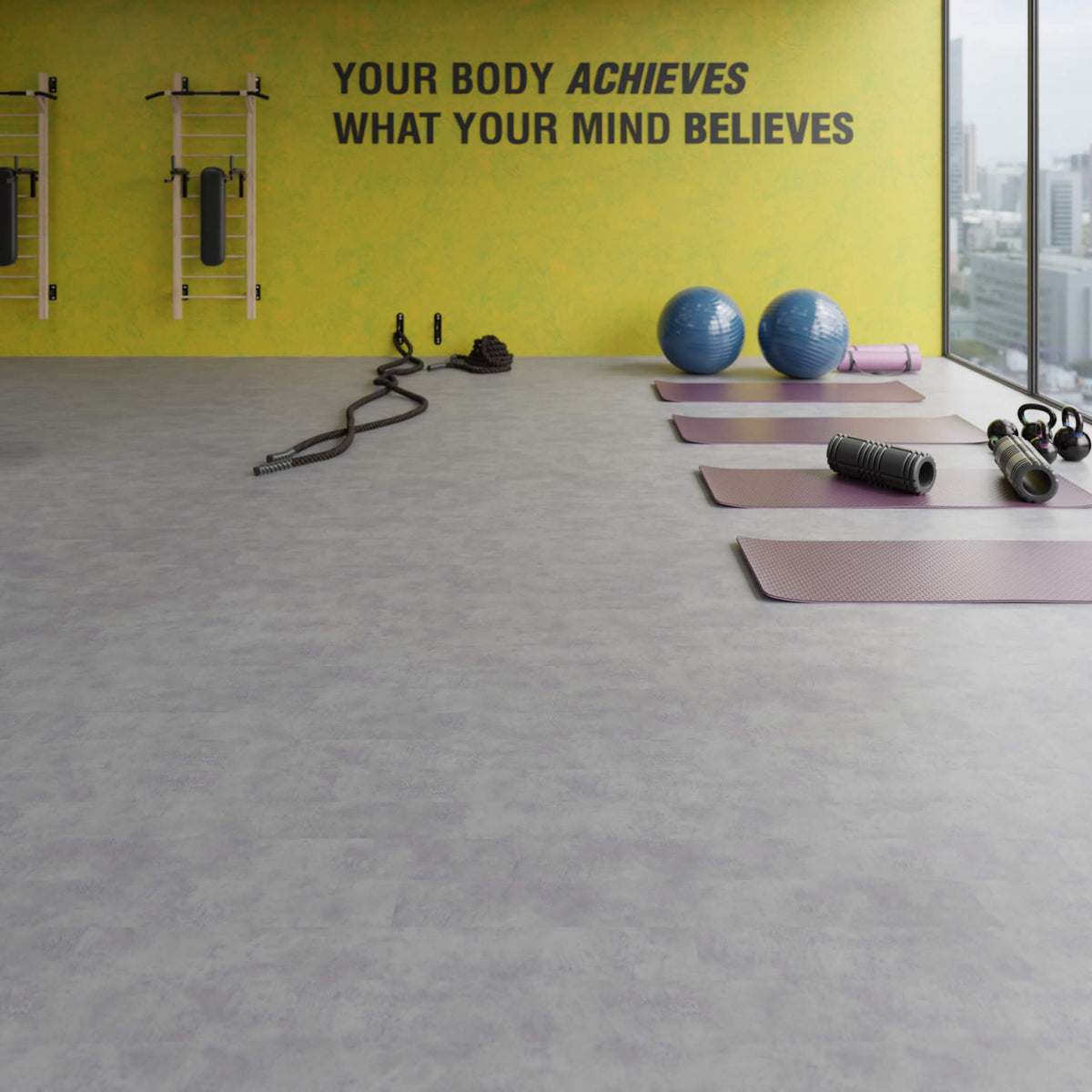 Gym interior with motivational quote on wall, kettlebells, exercise balls, and mats on Waterblock X Joku dark grey stone-look floor.